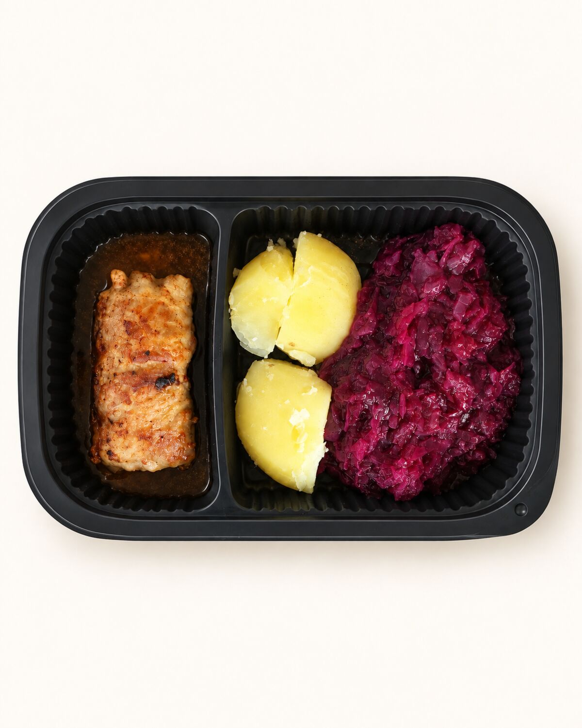 Maaltijdbak met een gebakken slavink, gestoofde rodekool en gekookte aardappelen.