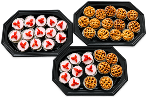 Schalen met kleine aardbeienkwarktaartjes en mini appeltaartjes, klaar om neer te zetten.